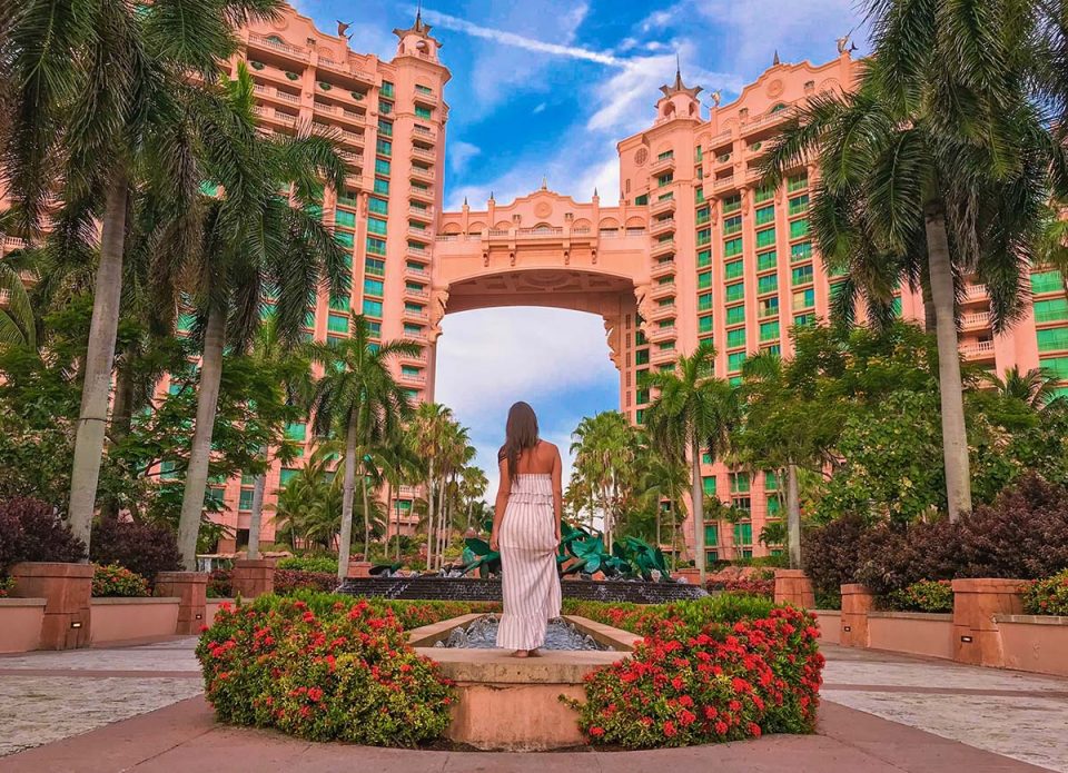 Girl Looking up Towards Atlantis Bahamas Resort on Paradise Island Things to do in Atlantis Vacation Couple