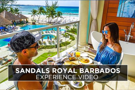Kristin and Shadi of Vacation Couple on their balcony having room service breakfast Cover photo for our Sandals Royal Barbados review.