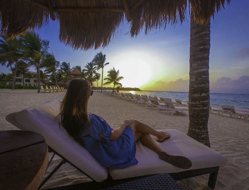 girl sitting on beach chair gazing at sunrise