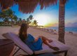 girl sitting on beach chair gazing at sunrise