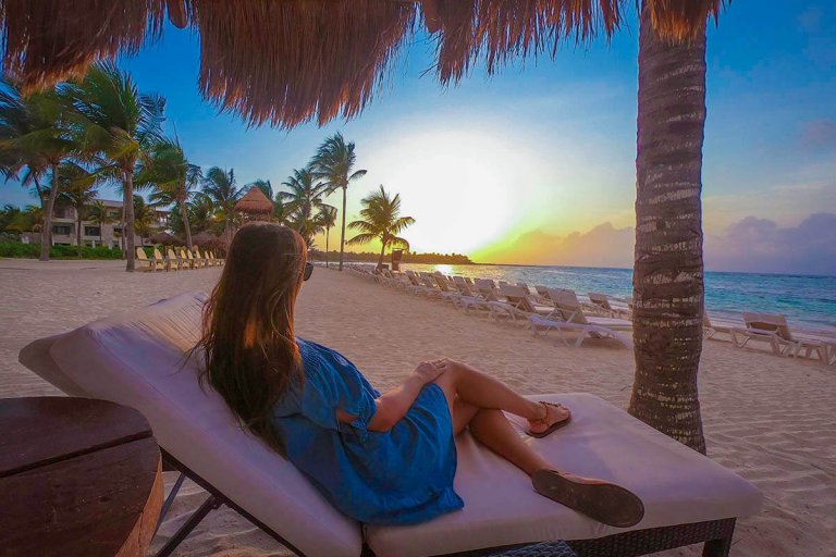 girl sitting on beach chair gazing at sunrise
