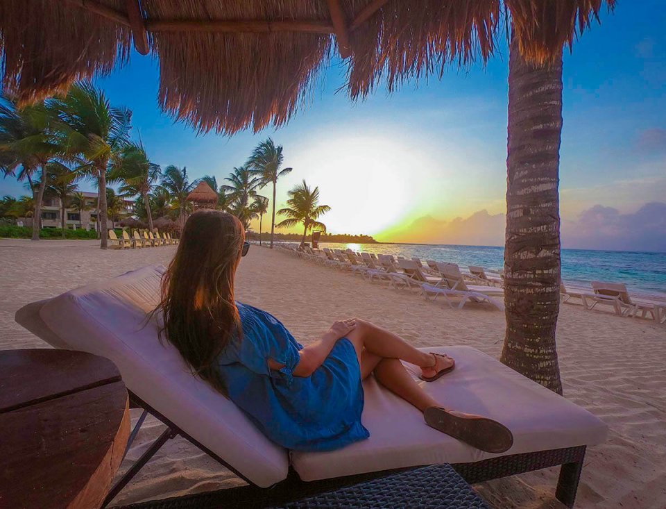 girl sitting on beach chair gazing at sunrise